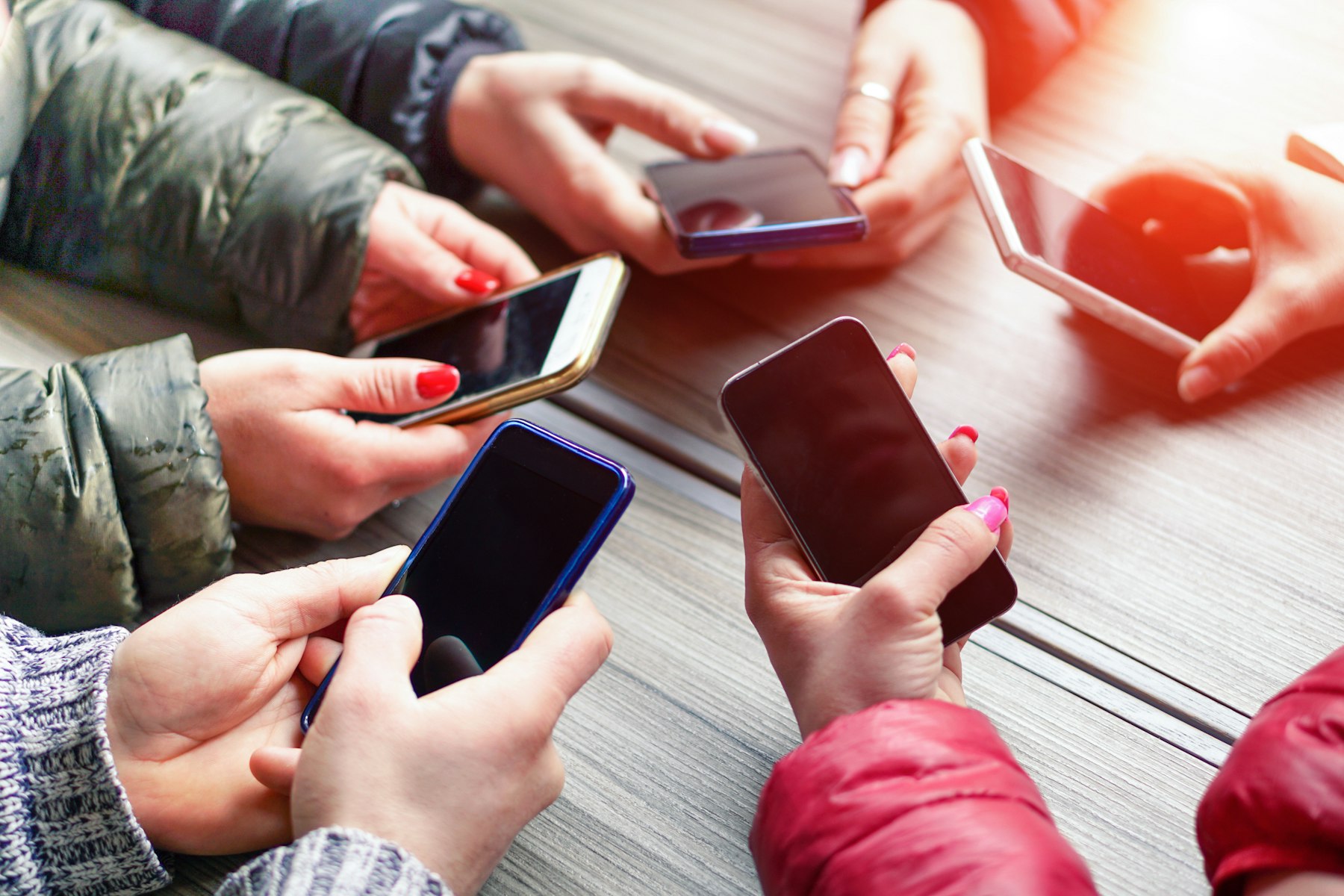 Image avec des smartphone qui sont tendus à bout de bras par des ados.