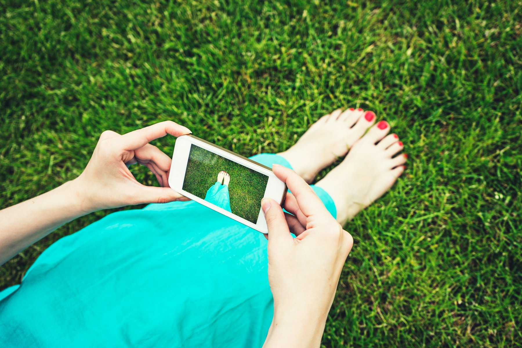 personne prenant une photo de ses pieds avec son smartphone