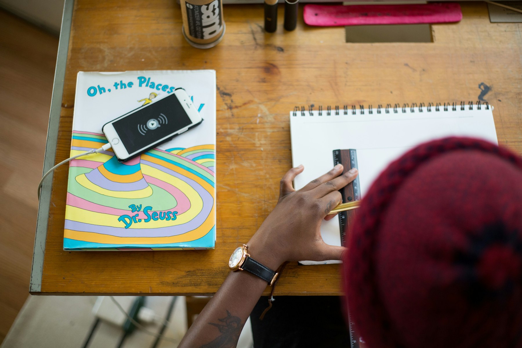 Image d'un jeune qui fait ses devoirs pour l'école avec son téléphone à côté de lui sur la table
