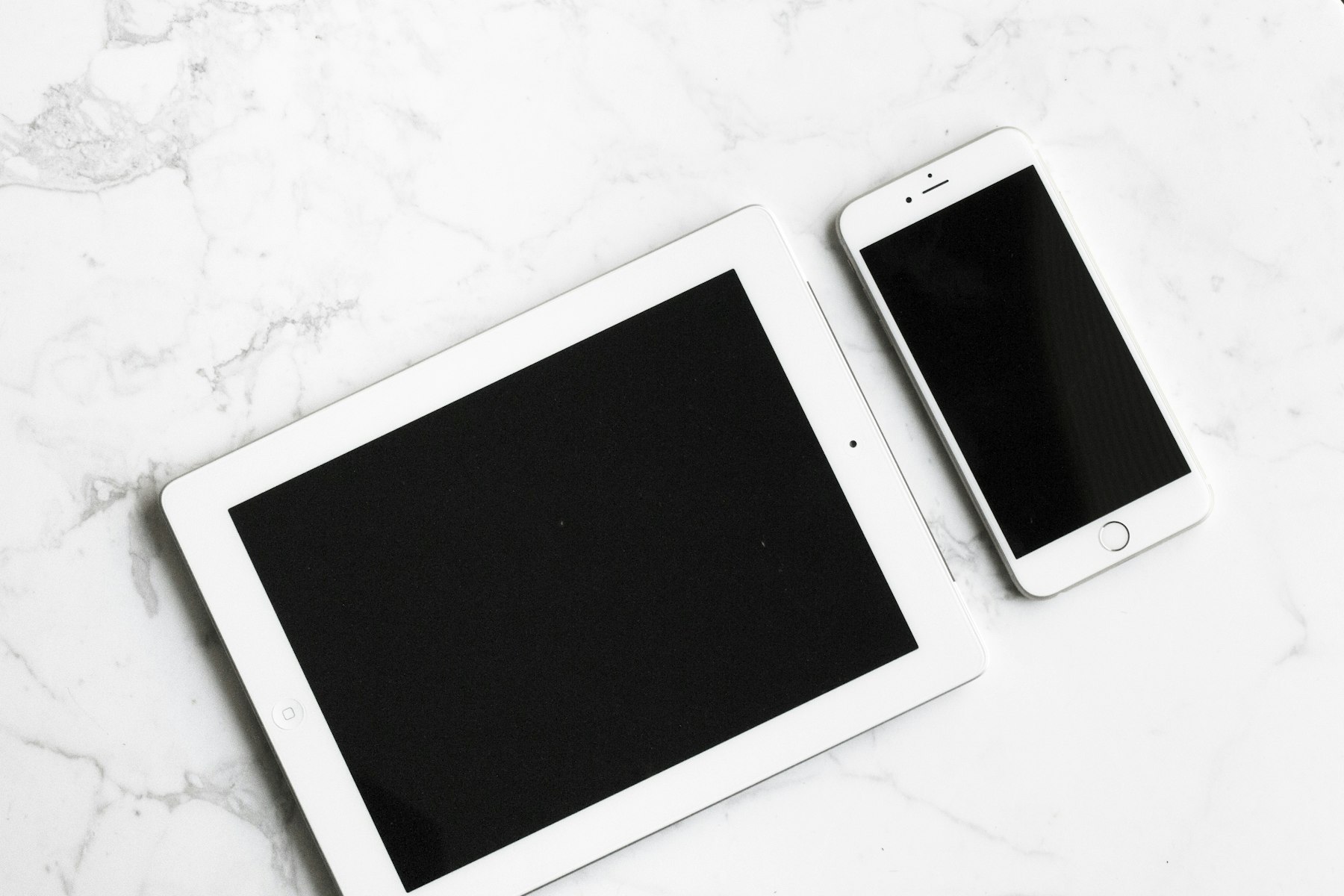 Image représentant une tablette et un téléphone mobile sur une table blanche